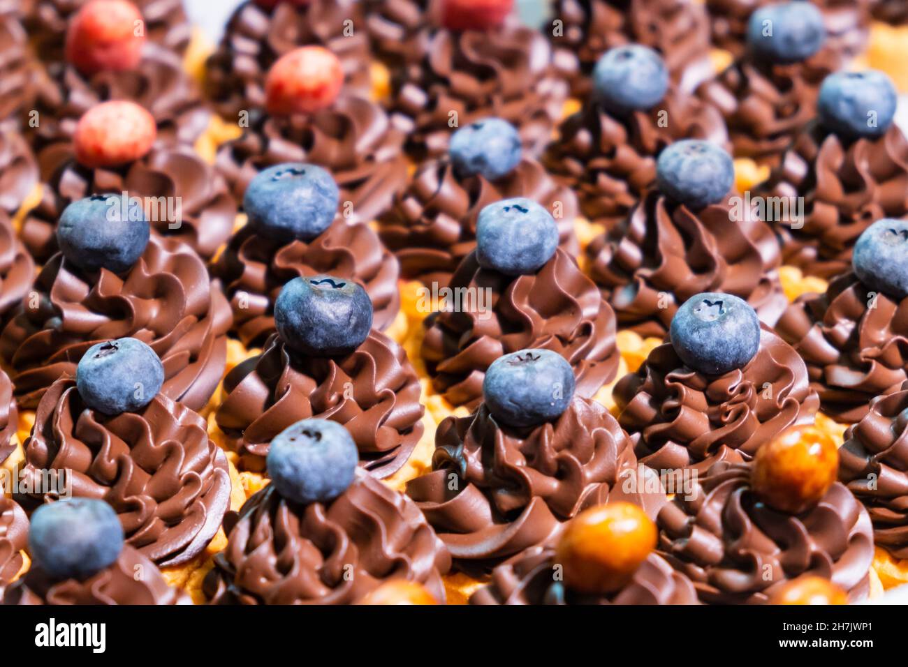 Petits gâteaux à la crème décorés de baies.Concept de barre de bonbons pour fête d'anniversaire, mariage, 8 mars, Fête des mères, Saint Valentin. Banque D'Images