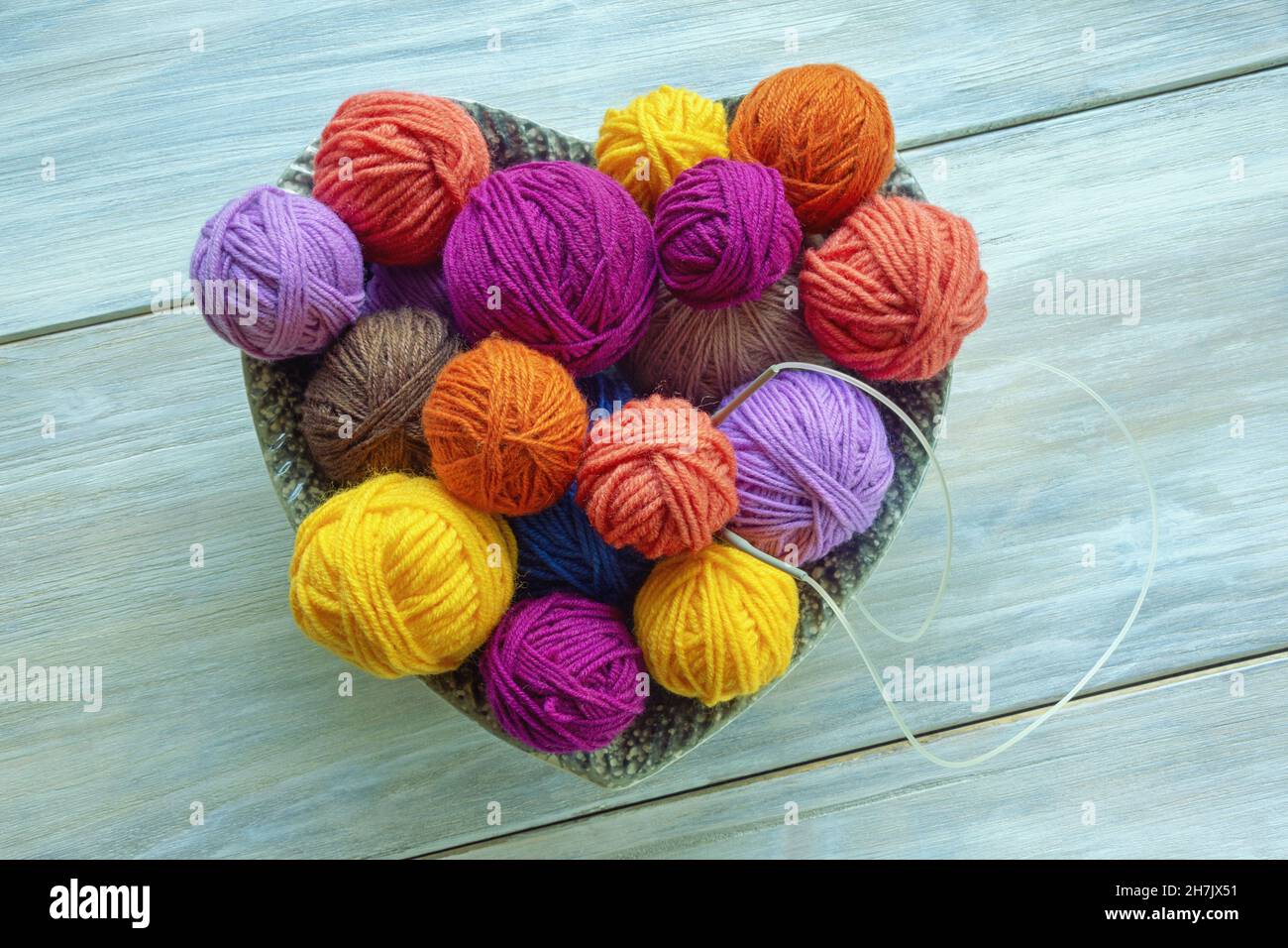 Boules de laine multicolores et aiguilles à tricoter sur une table rustique.Passe-temps et concepts de tricotage.Flat lay, espace de copie Banque D'Images