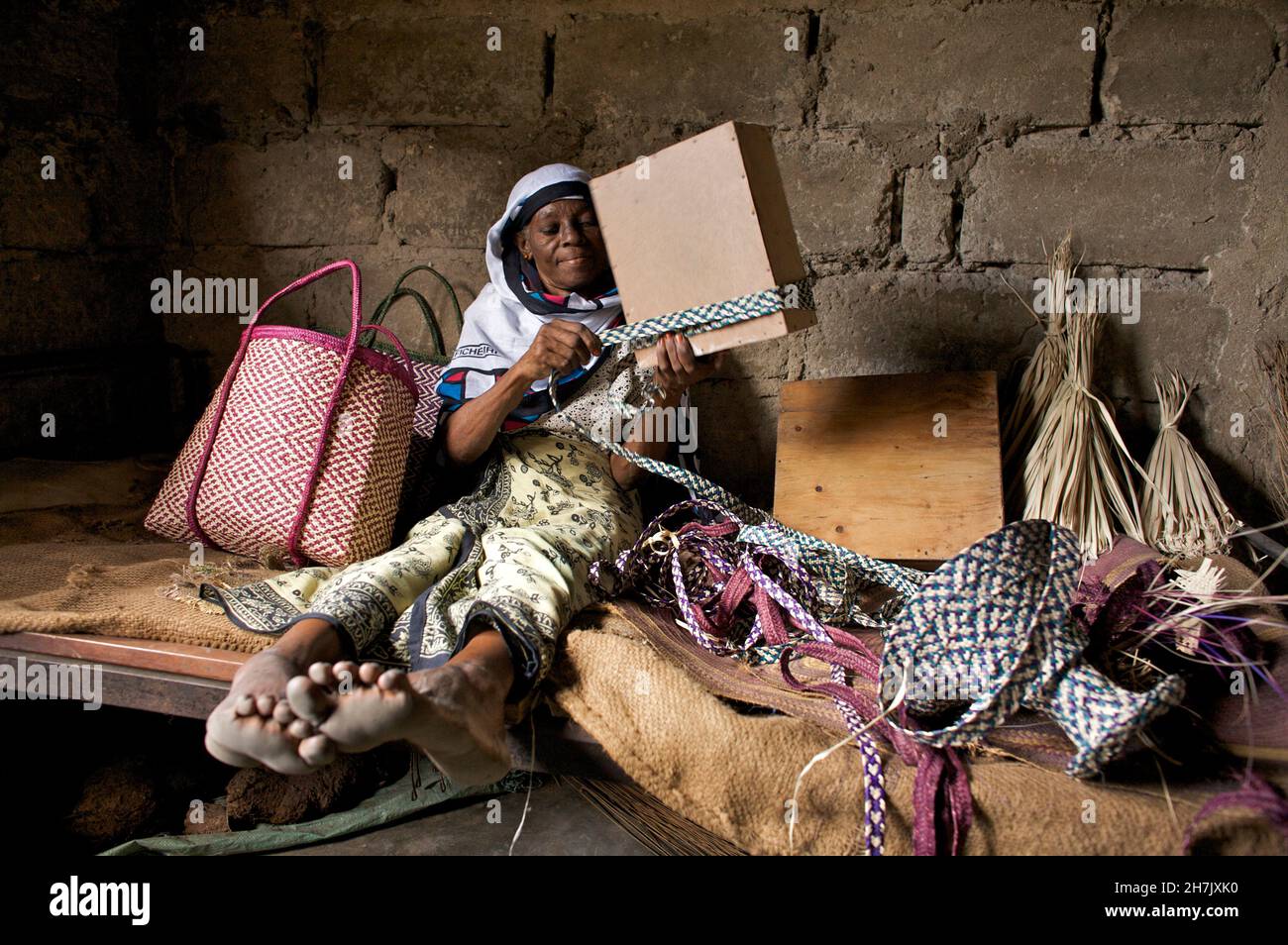 Mzuri Juma, 48 ans, déversait des paniers de pailles dans la région de Jangombe à Zanzibar.En plus des paniers, elle vend du charbon de bois de sa maison pour la compléter Banque D'Images