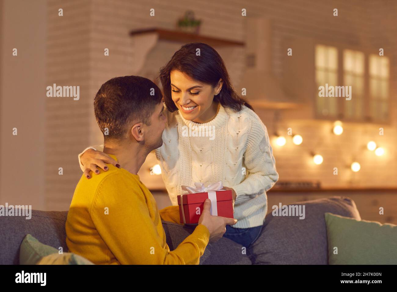 Jeune aimant heureux couple souriant donnant des cadeaux de vacances pendant la fête de la Saint Valentin Banque D'Images