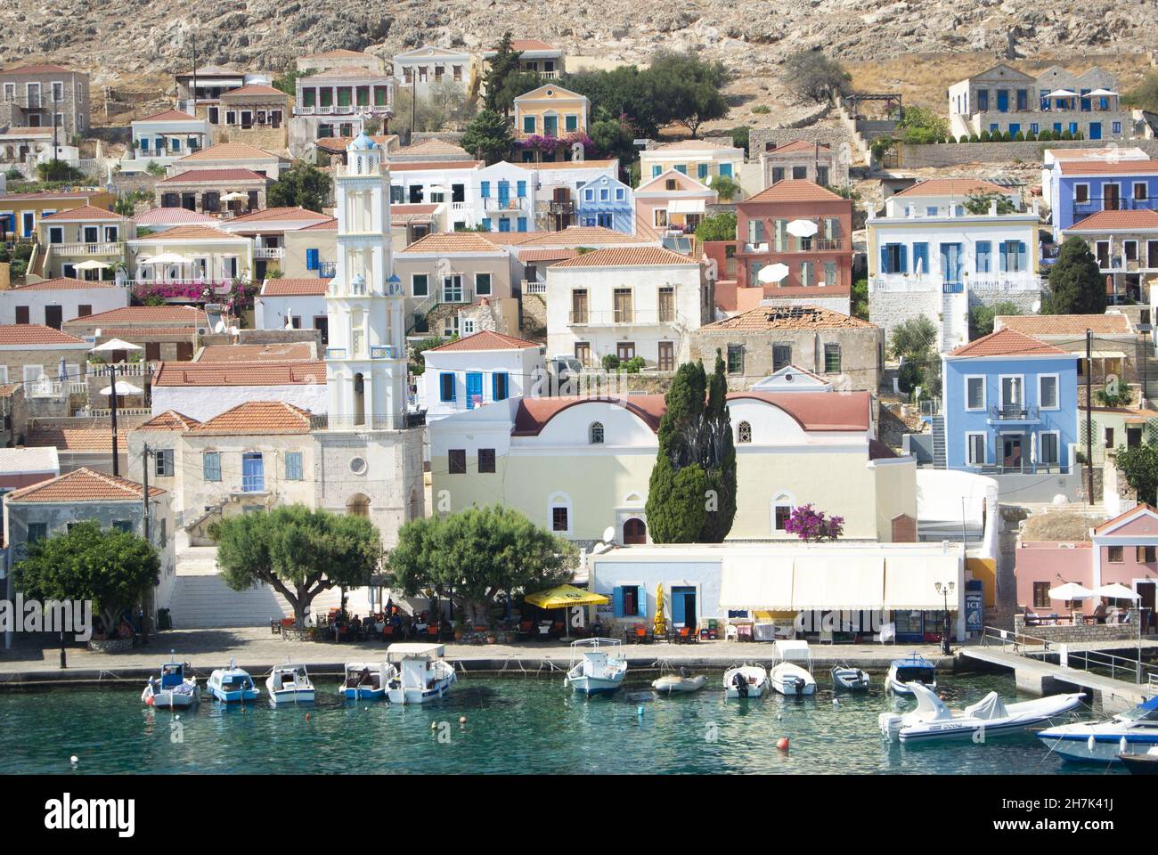 Île Chalki - Grèce - août 26 2014 : charmante scène portuaire, port de Halki.Vue sur les élégantes maisons de ville autour du front de mer coloré Banque D'Images