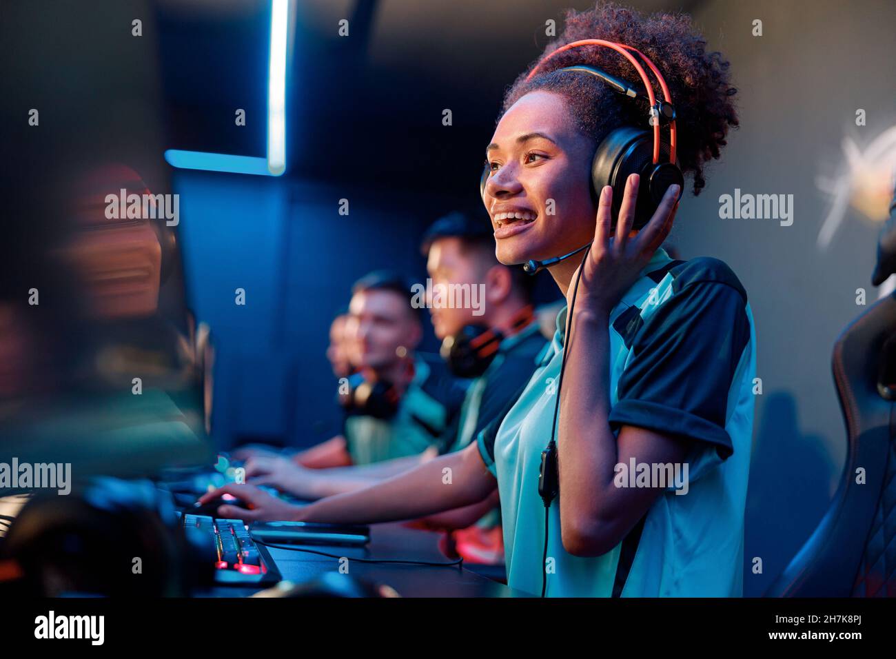 Une jeune femme dans un casque joue à un jeu informatique dans un club Internet Banque D'Images