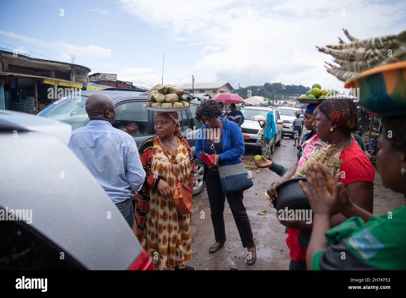 Une femme africaine avec des paniers de nourriture sur leur tête vend leurs produits dans la rue, la vie traditionnelle au Cameroun Banque D'Images