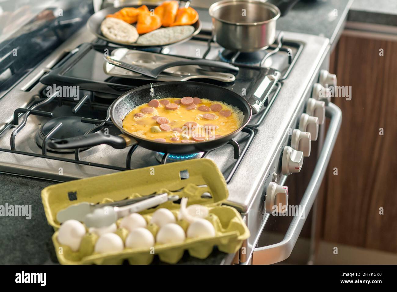Poêle à frire avec œufs brouillés, saucisses et enchiladas Banque D'Images