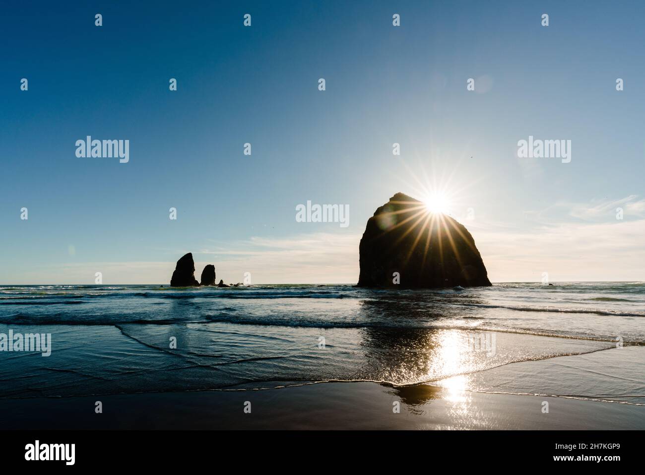 Le soleil se couche derrière le rocher de haystack sur Cannon Beach dans l'Oregon Banque D'Images