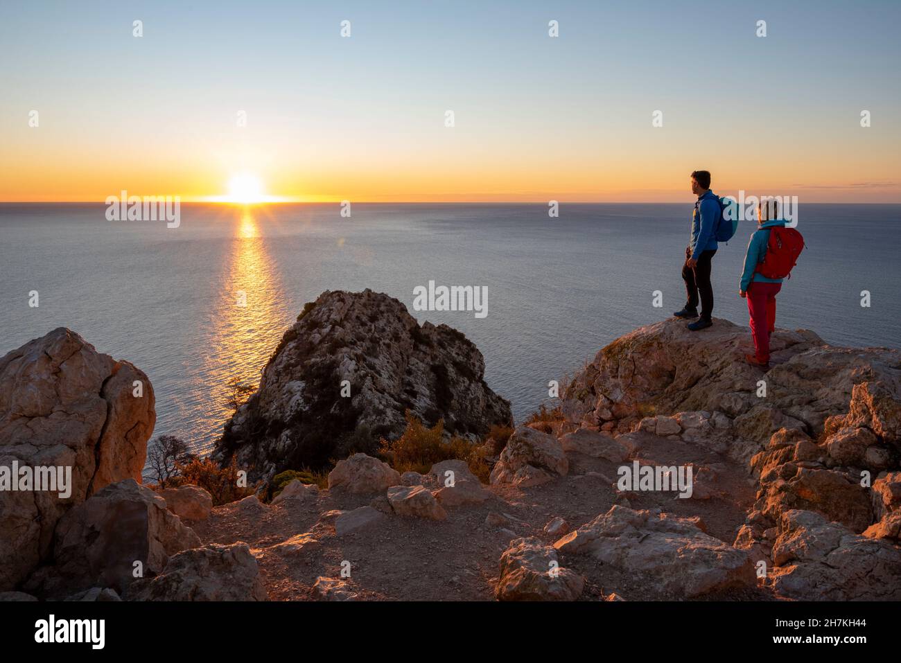 Deux randonneurs se tiennent au sommet au-dessus de la mer méditerranée et des collines et regardent, Calpe, province d'Alicante, Espagne Banque D'Images