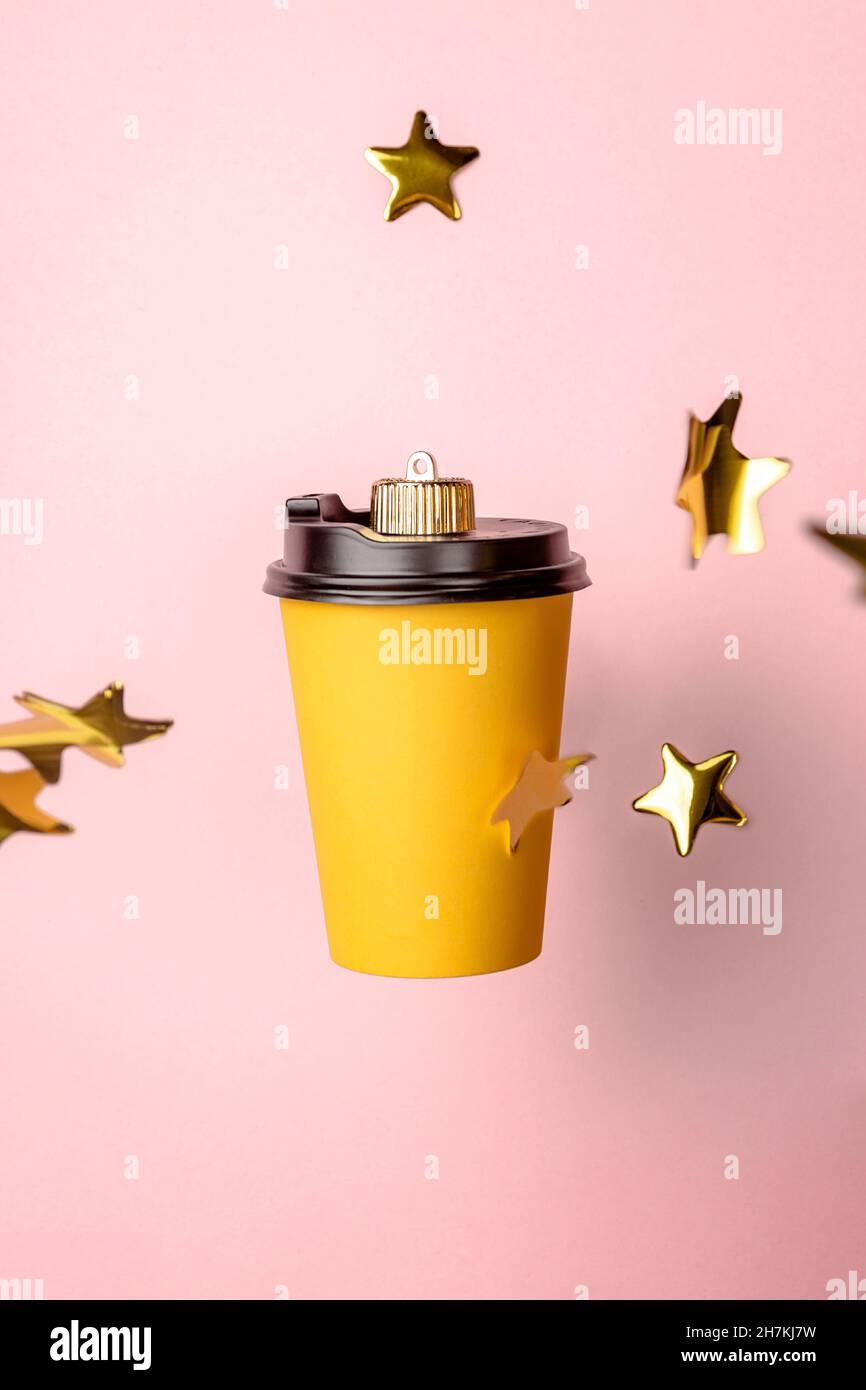décoration de boule de noël faite de tasse à café jetable sur fond rose avec des étoiles d'or. Concept minimal du nouvel an. Gros plan Banque D'Images