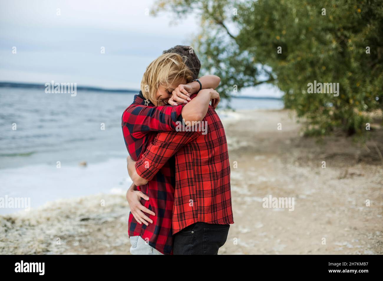 Petite amie et petit ami qui s'embrassent les uns les autres à la plage Banque D'Images