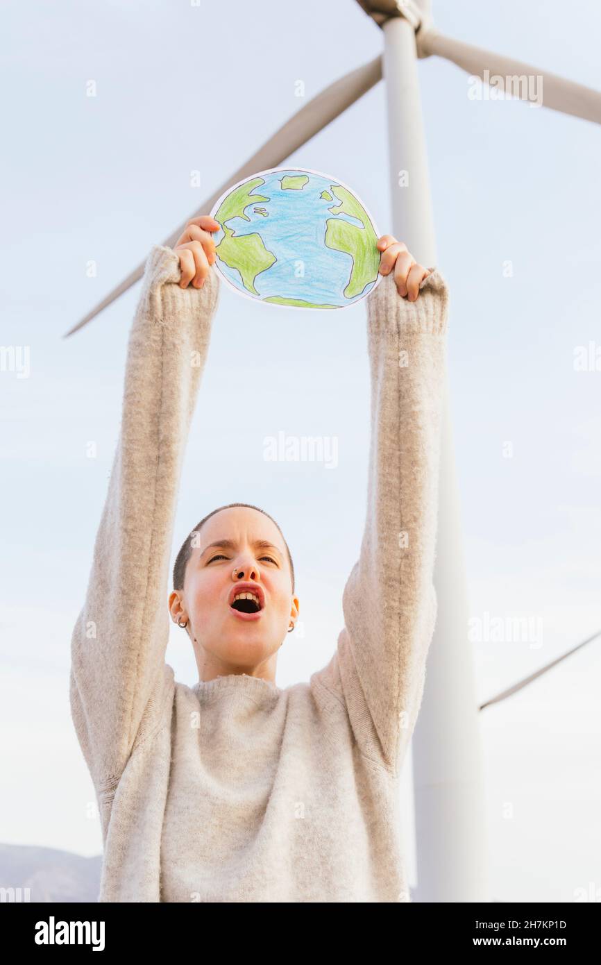 Une femme hurle tout en tenant le dessin de terre à l'éolienne Banque D'Images