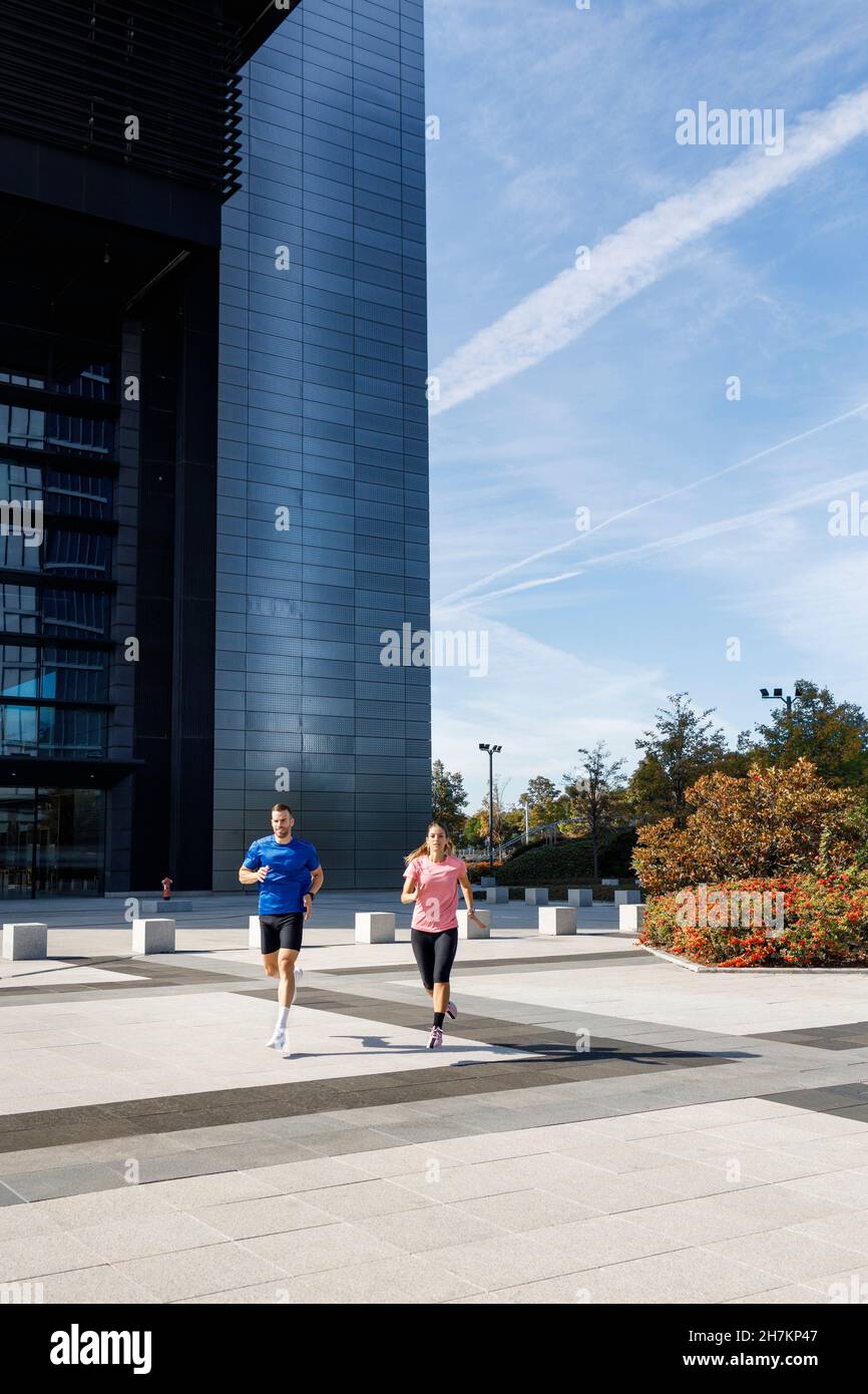 Jeune sportif en train de courir avec une femme sur la piste Banque D'Images