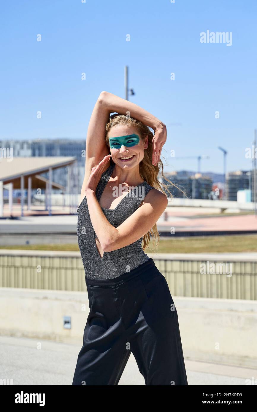 Femme souriante gestante signe de main debout dans la rue le jour ensoleillé Banque D'Images