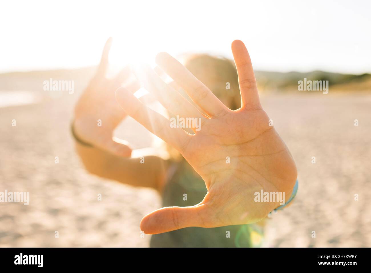 Jeune femme faisant un geste d'arrêt avec les mains à la plage Banque D'Images