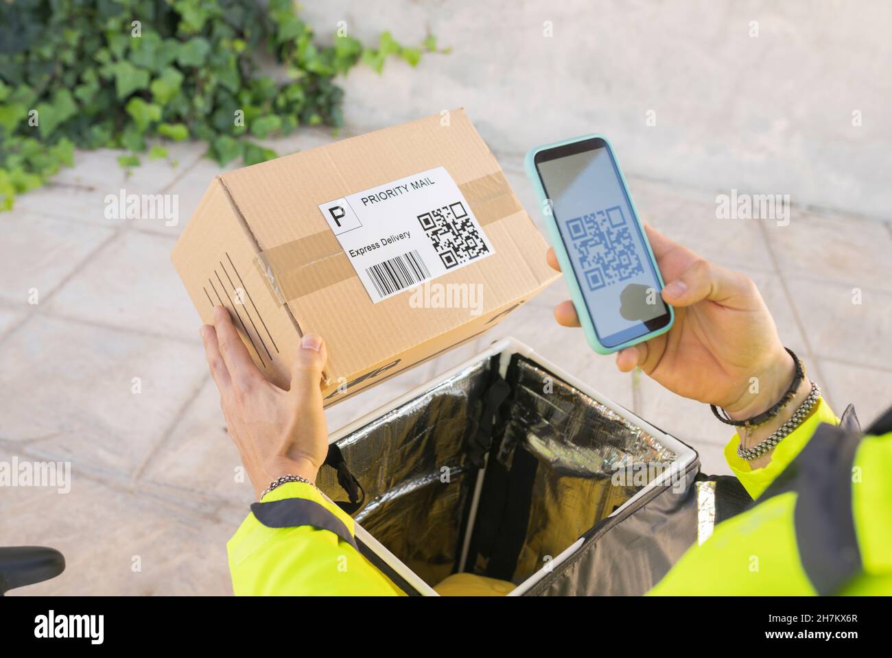 Le liveur recherche la position sur le plan de la ville via un smartphone Banque D'Images