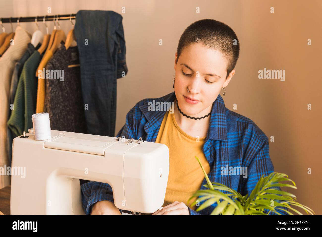 Une femme de mode couture des vêtements en machine à l'atelier Banque D'Images