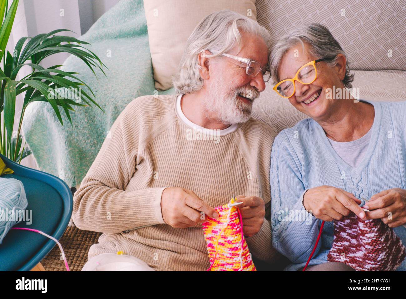 Couple avec aiguille tricotage souriant à la maison Banque D'Images