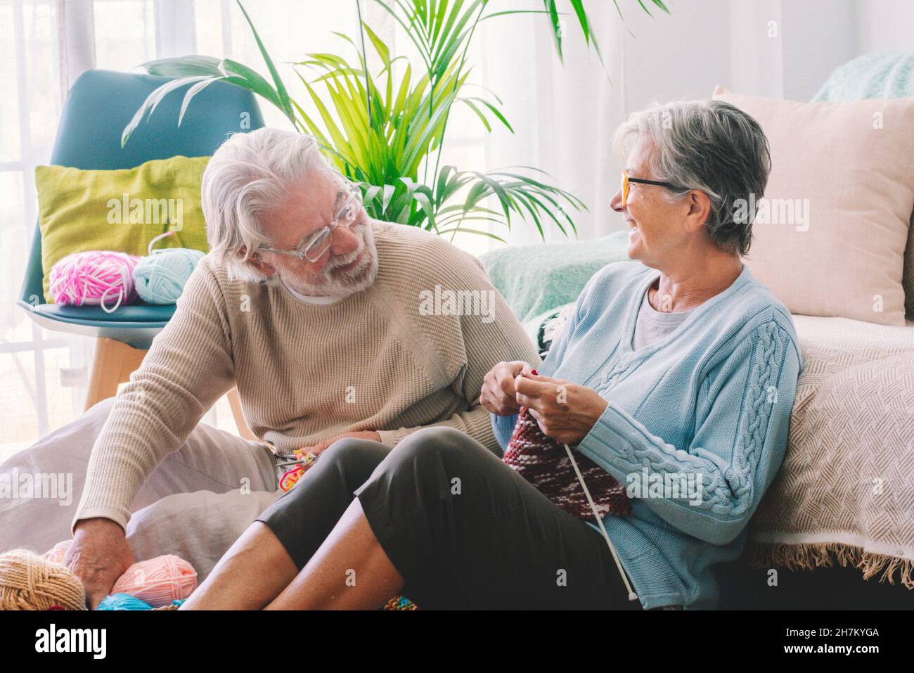 Couple senior avec aiguille tricotage assis dans le salon Banque D'Images