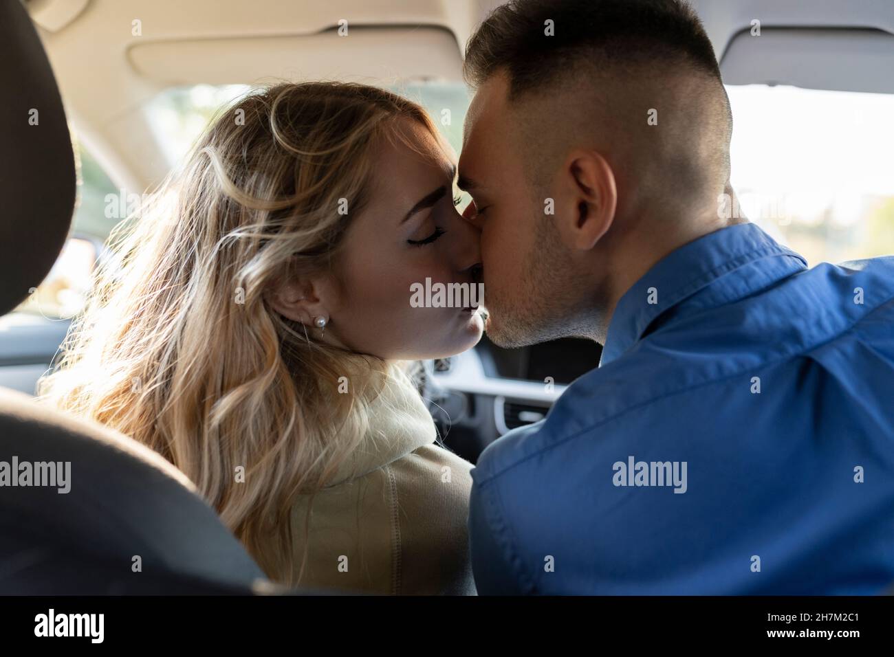 Young woman driving car au coucher du soleil Banque D'Images