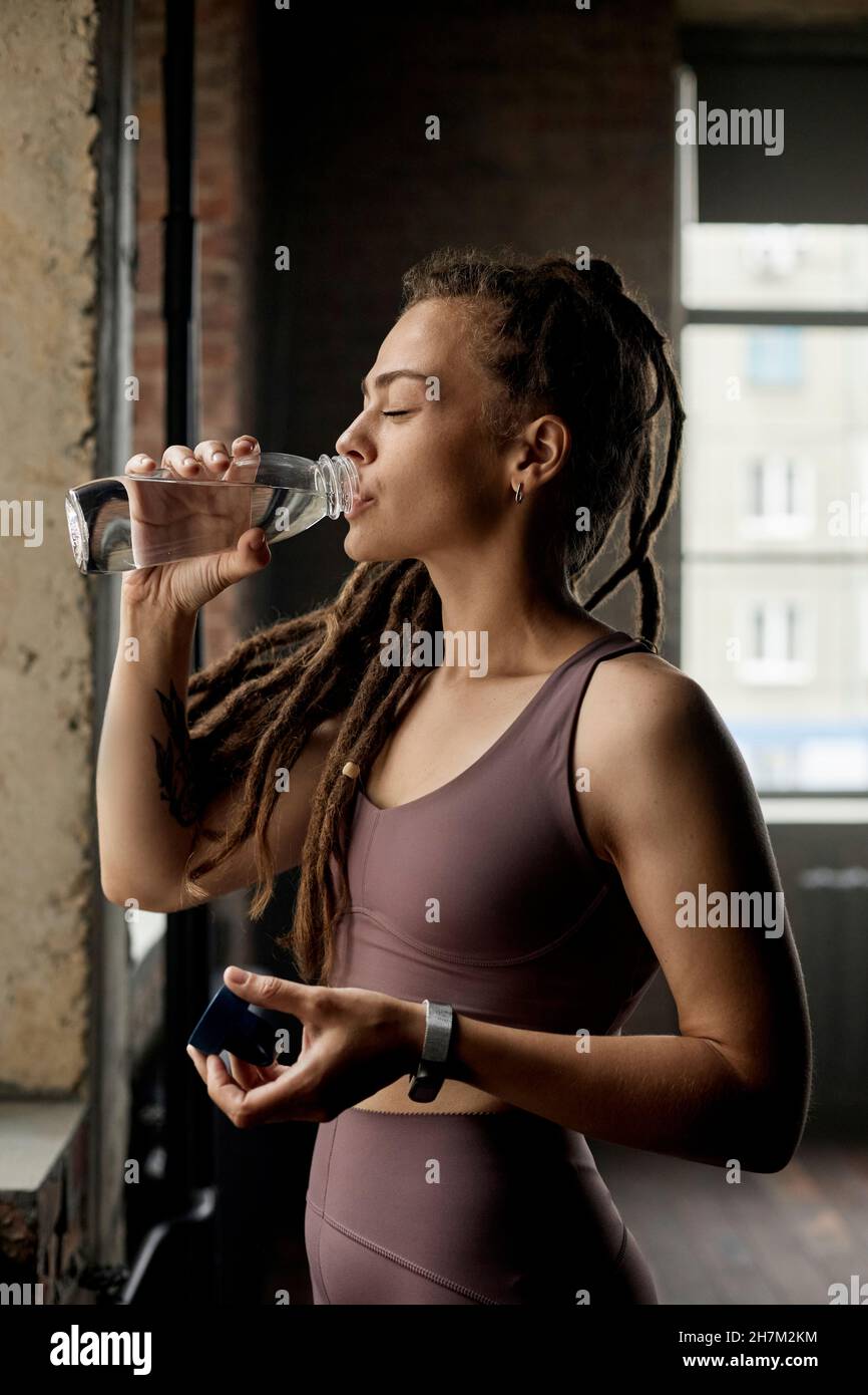 Eau potable Sportswoman dans le studio de fitness Banque D'Images