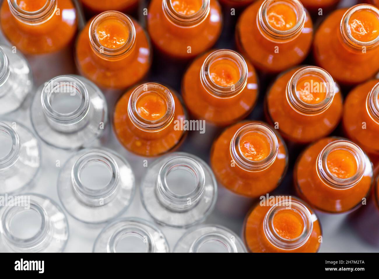 Bouteilles de sauce Chili disposées côte à côte dans l'usine de production Banque D'Images