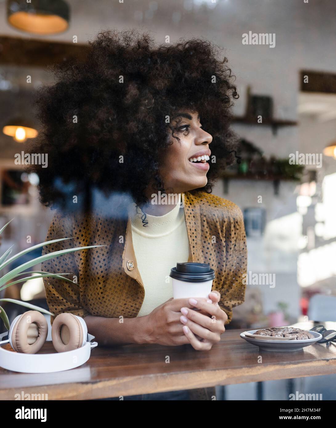 Femme avec code QR payant par téléphone portable au café Banque D'Images
