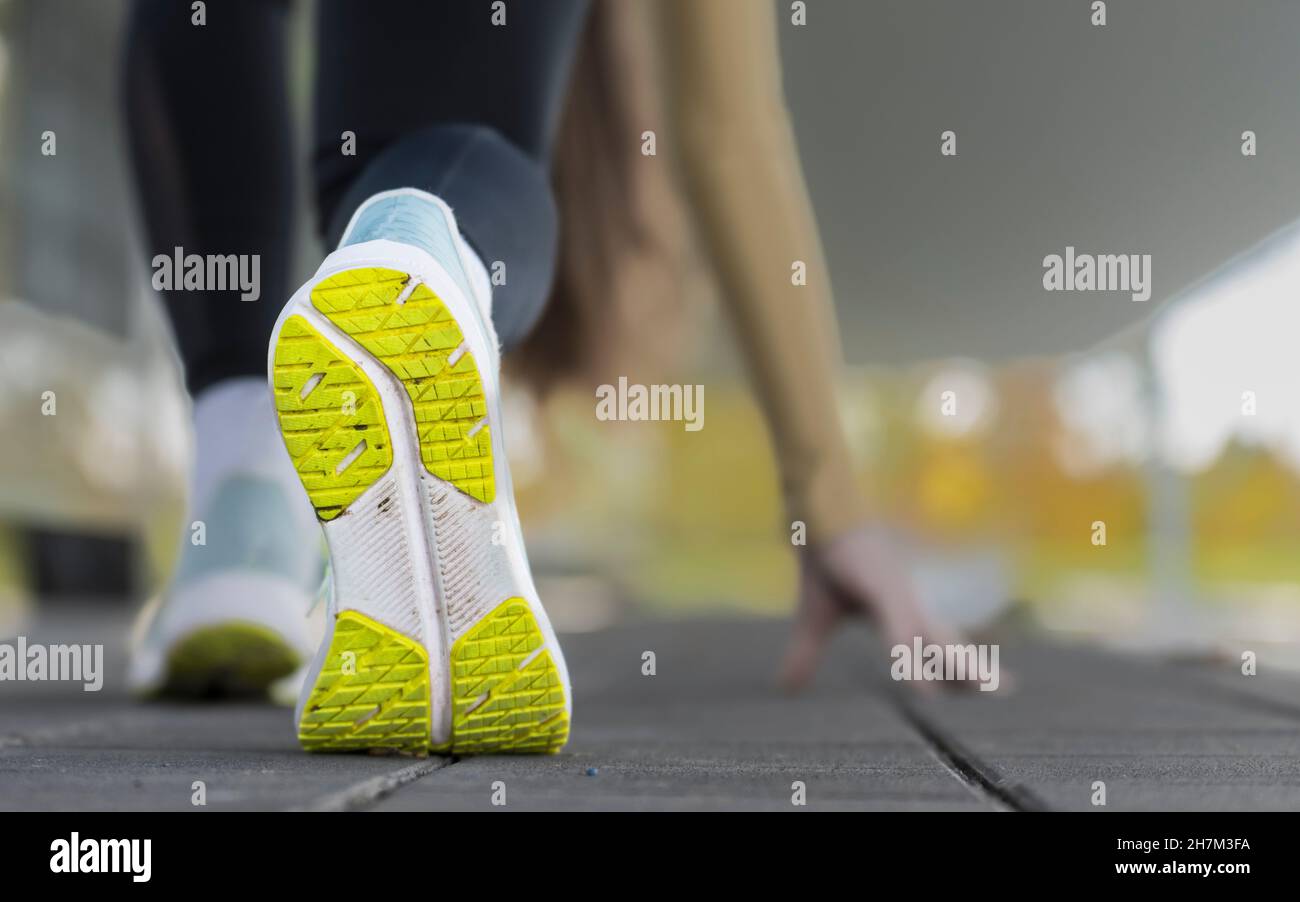 Semelle de la chaussure de sport de la jeune femme s'étirant à l'extérieur avant le jogging du matin Banque D'Images