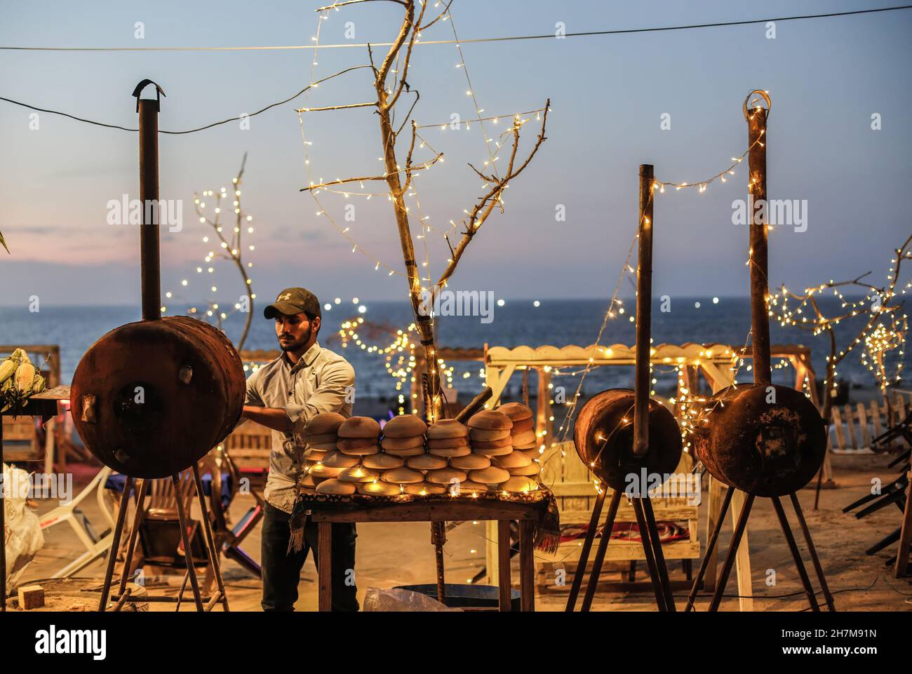 Un vendeur de rue palestinien a grillé du maïs sur une plage de Gaza pendant le coucher du soleil.(Photo de Mahmoud Issa / SOPA Images / Sipa USA) Banque D'Images
