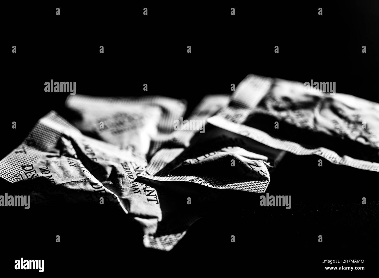 sachets de dessiccant dispersés sur une surface sombre Banque D'Images