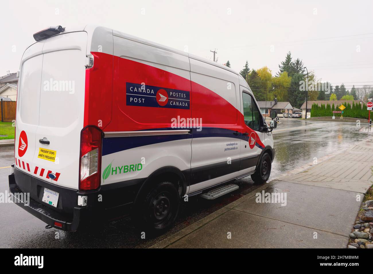Une fourgonnette hybride rouge et blanche utilisée par postes Canada garée quelque part dans le Lower Mainland, B.,C., Canada. Banque D'Images