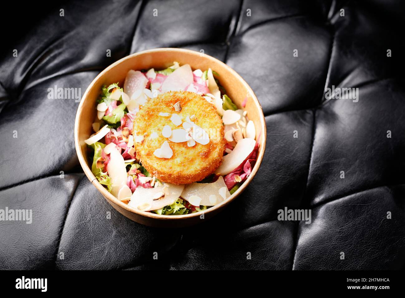 Fromage camembert frit sur une salade verte.À emporter, boîte de régime.Plat prêt-à-emporter appétissant servi dans une boîte jetable.Photographie culinaire.Fond de nourriture Banque D'Images