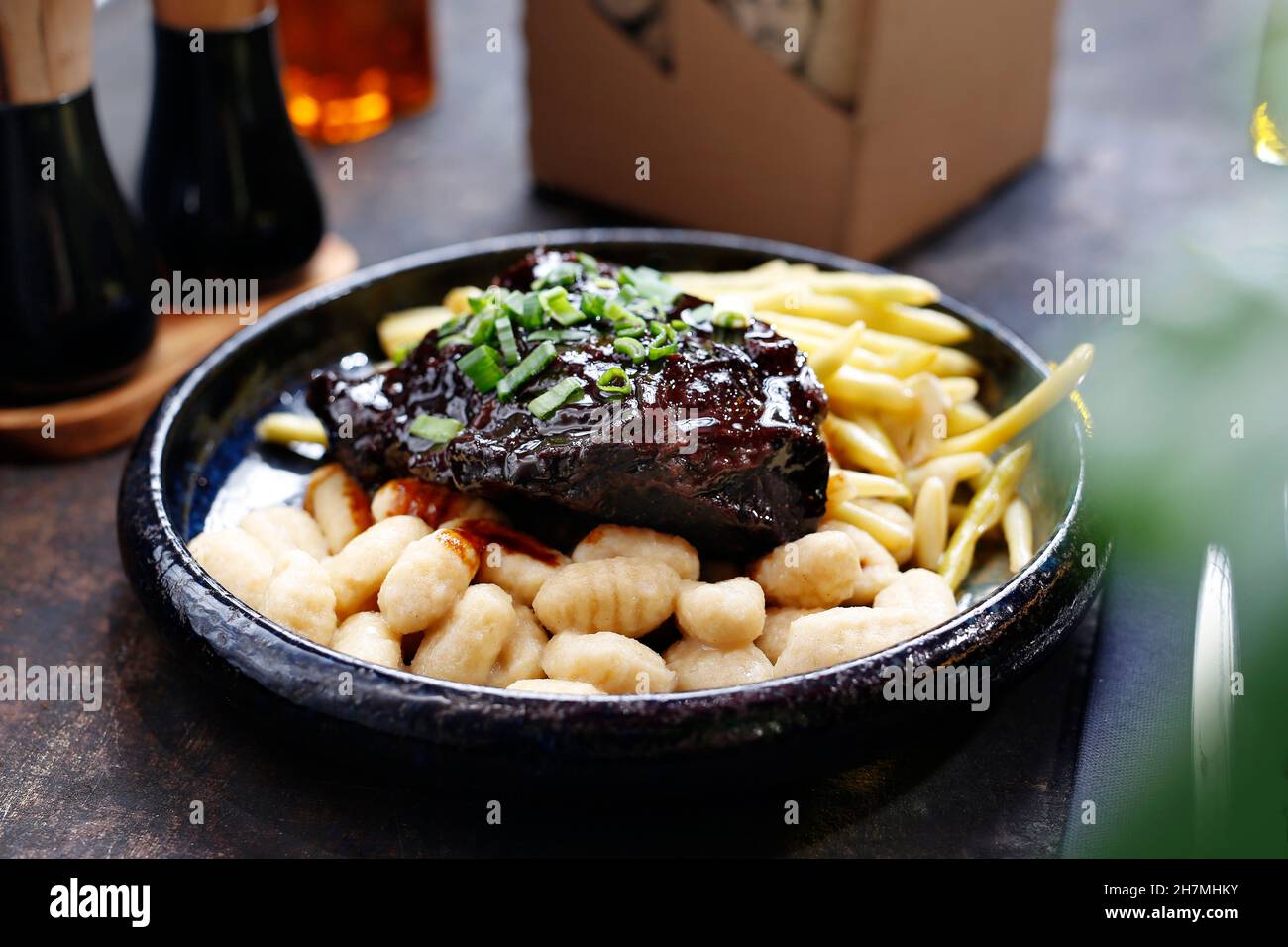 Viande rôtie en sauce barbecue avec frites et gnocchi.Un délicieux plat.photographie culinaire.Suggestion de servir le plat. Banque D'Images