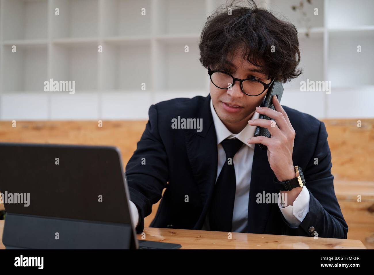 Portrait d'un homme d'affaires asiatique jeune homme d'affaires souriant entrepreneur gai dans un bureau décontracté faisant un appel téléphonique tout en travaillant avec une tablette numérique Banque D'Images
