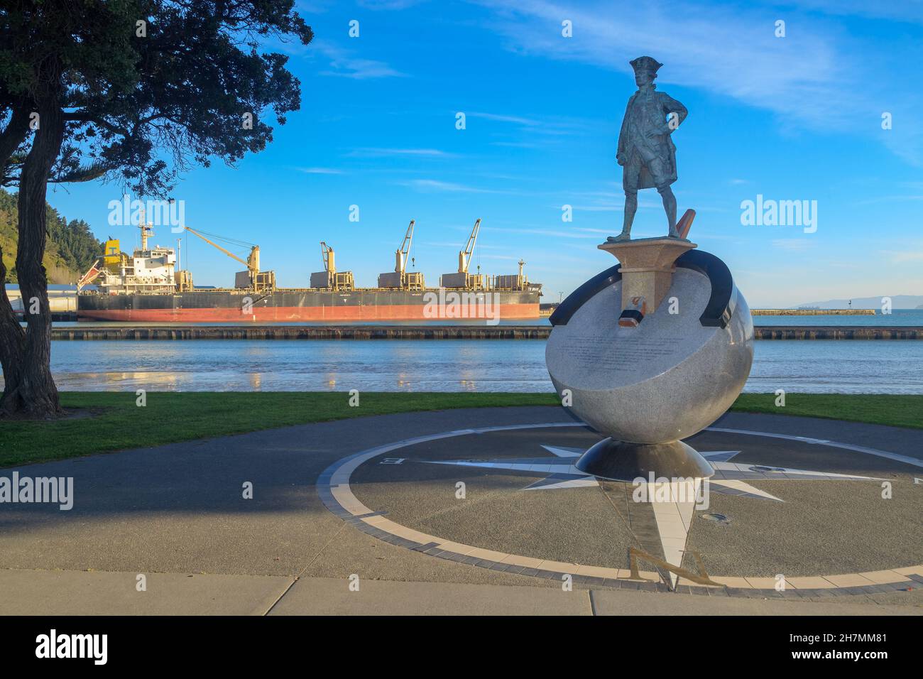 Statue de l'explorateur anglais du XVIIIe siècle James Cook à Gisborne, Nouvelle-Zélande.En arrière-plan se trouve un navire de cargaison Banque D'Images