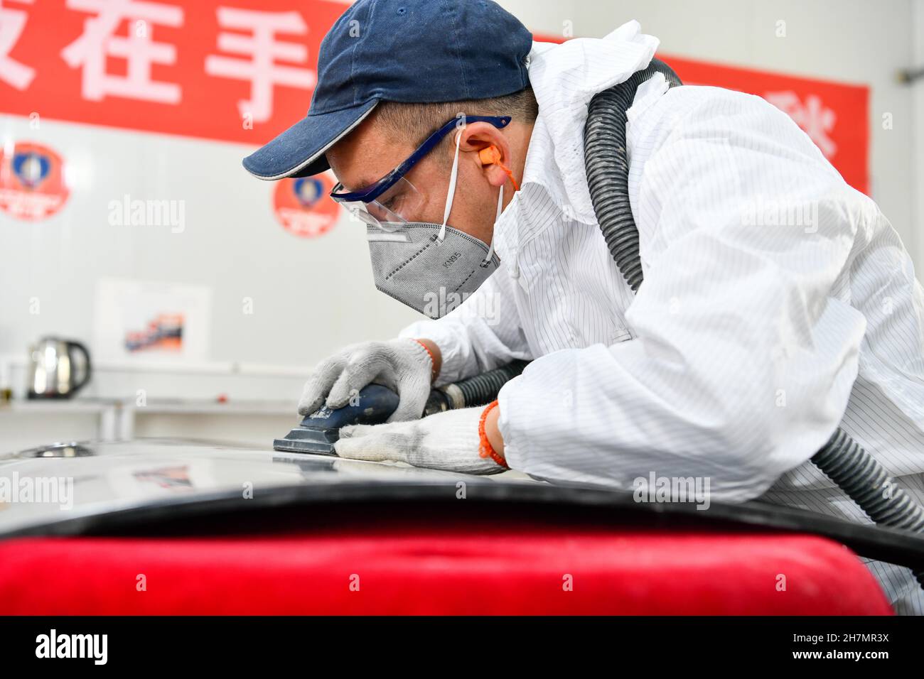 Longli, province chinoise du Guizhou.23 novembre 2021.Un concurrent participe au concours de peinture automobile lors d'un concours de compétences professionnelles dans le comté de Longli, dans la province de Guizhou, dans le sud-ouest de la Chine, le 23 novembre 2021.Credit: Yang Wenbin/Xinhua/Alamy Live News Banque D'Images