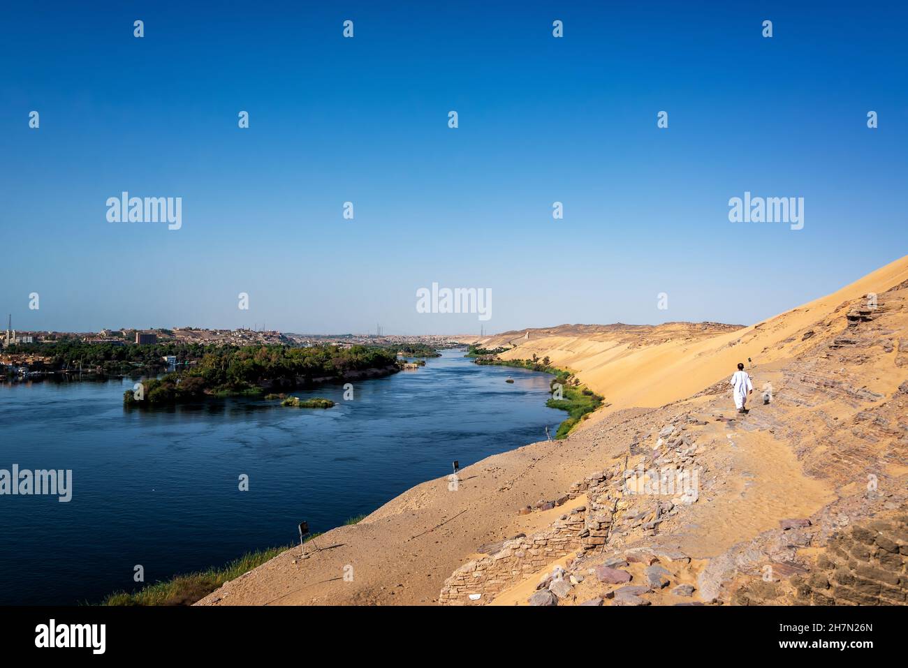 ASSOUAN, ÉGYPTE - 30 JUILLET 2021 : l'homme marche sur des dunes de sable au-dessus du Nil à Assouan, Égypte, le 30 juillet 2021 Banque D'Images