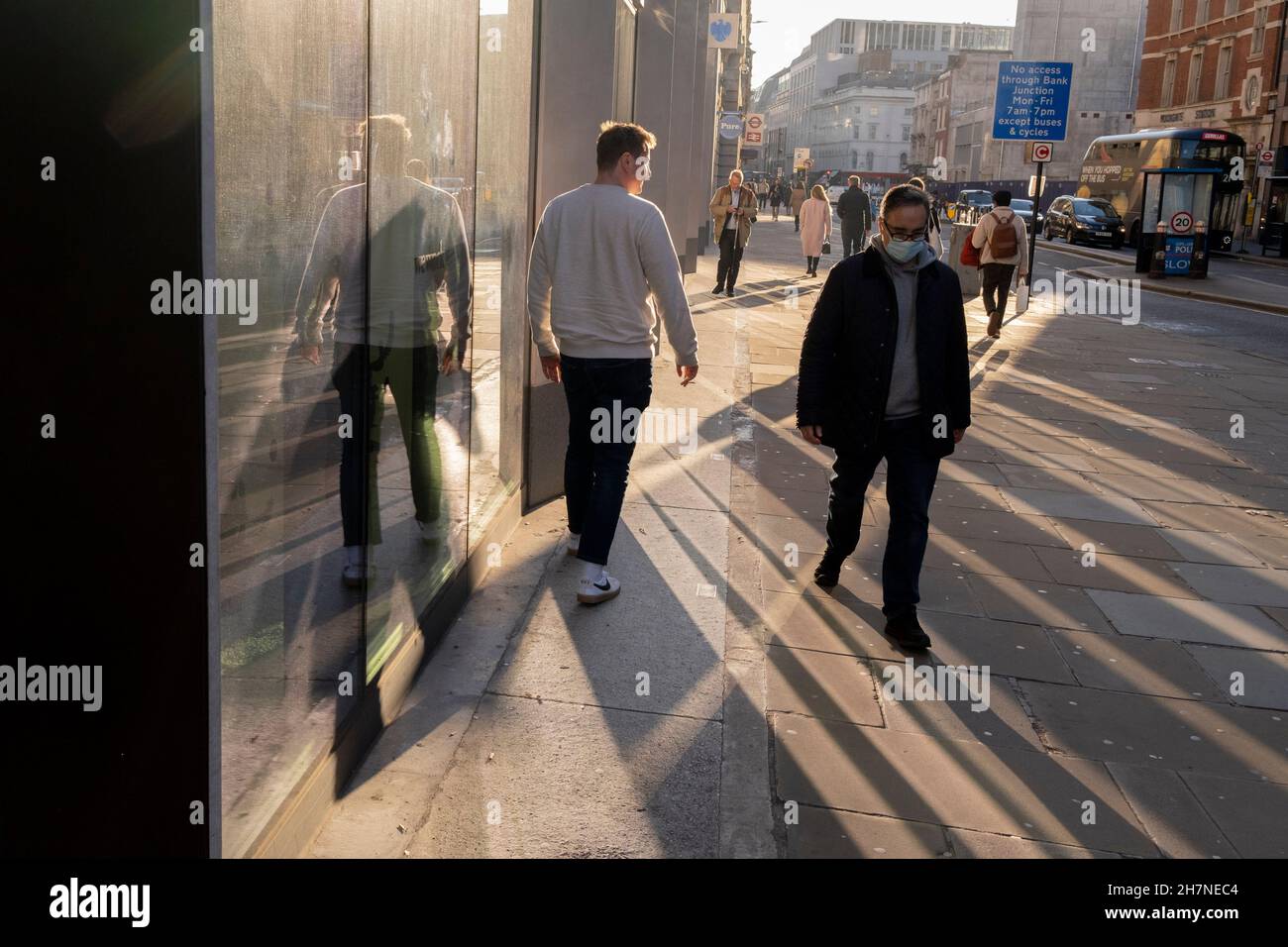 Des piétons traversent la lumière solaire d'automne réfléchie sur Moorgate dans la City de Londres, le quartier financier de la capitale, le 23 novembre 2021, à Londres, en Angleterre. Banque D'Images