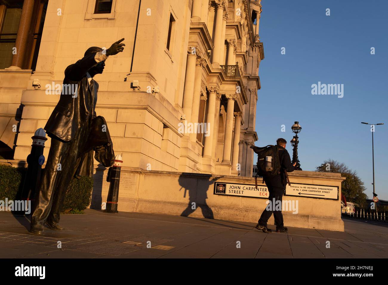 Un piéton passe devant la sculpture de J. Seward Johnson Jr, intitulée « taxi » (1993) sur la rue John Carpenter dans la ville de Londres, le quartier financier de la capitale, le 23 novembre 2021, à Londres, en Angleterre.« taxi » montre un employé de la ville avec une main, en portant un taxi.Il s'agit de l'une des 6 émissions réalisées par l'artiste américain et héritier de Johnson & Johnson. Banque D'Images