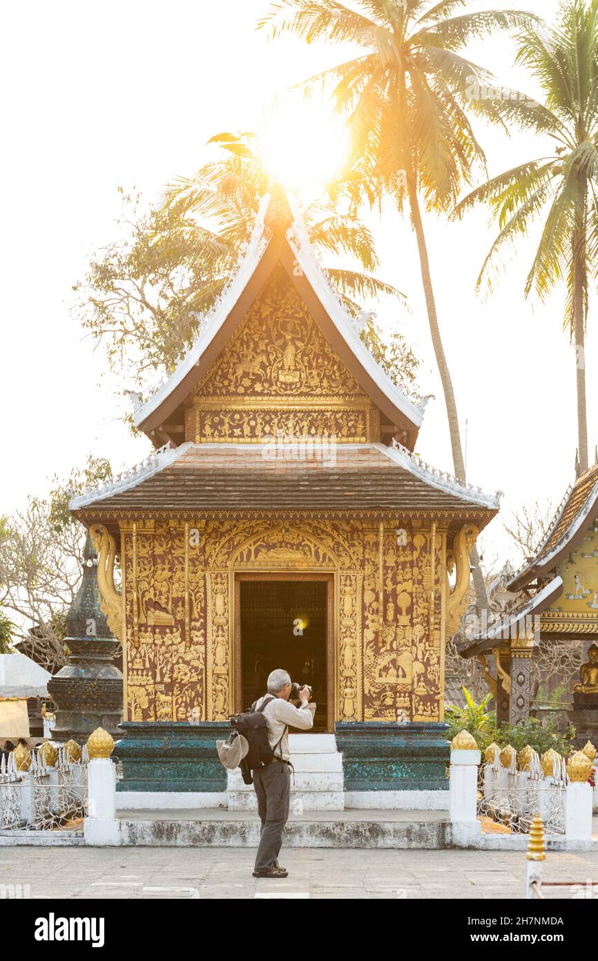 Un touriste prend des photos au beau Wat Xieng Thong (Temple de la ville d'or). Banque D'Images