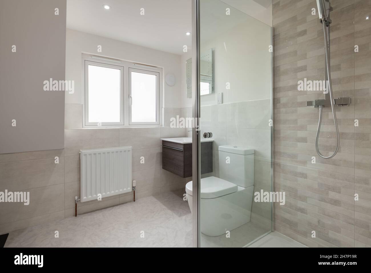 Salle de bains attenante moderne dans la nouvelle maison mise en vente avec cabine de douche