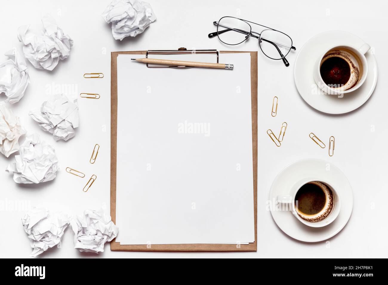 Des papiers froissés éparpillés, des tasses vides de café sur la table d'un travailleur de la création. Crise créative. Concept de stress, de troubles de santé mentale et de manque de moi Banque D'Images