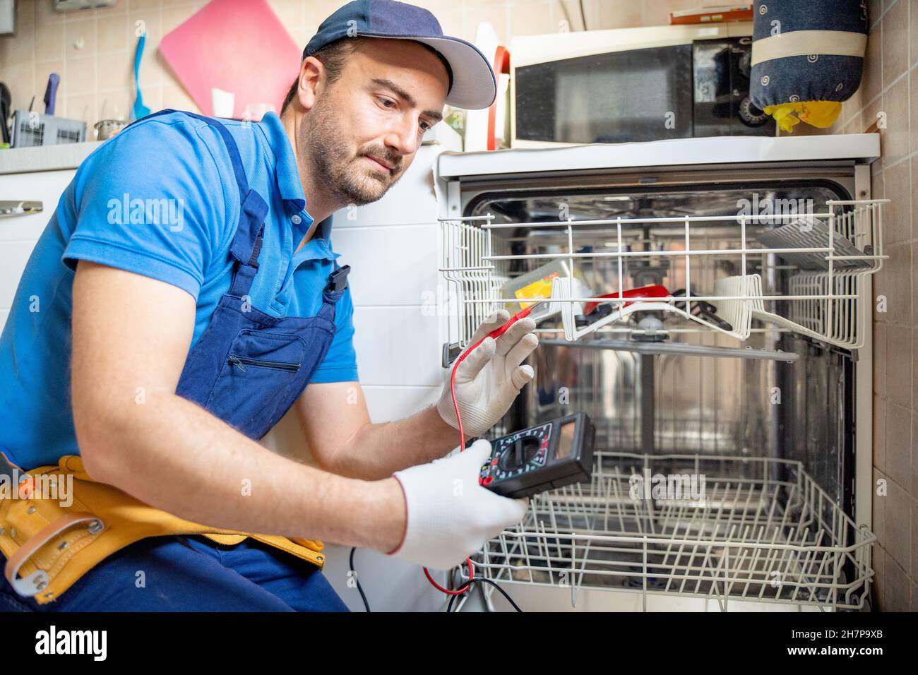 Un réparateur expert répare un lave-vaisselle cassé dans la cuisine Photo  Stock - Alamy