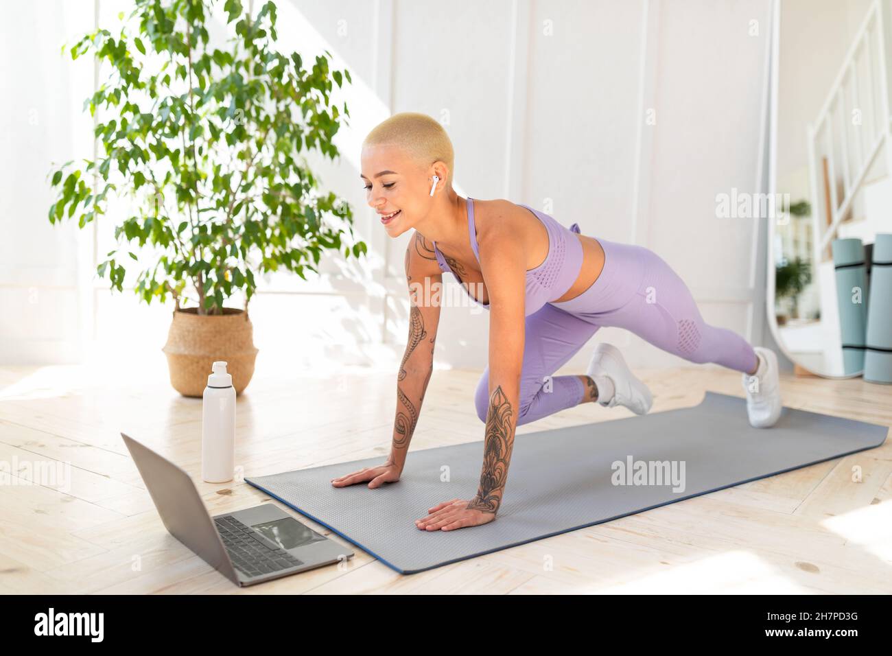 Fitness en ligne.Faites du sport à la maison avec un ordinateur portable, regardez des leçons en ligne et faites de l'exercice sur un tapis Banque D'Images