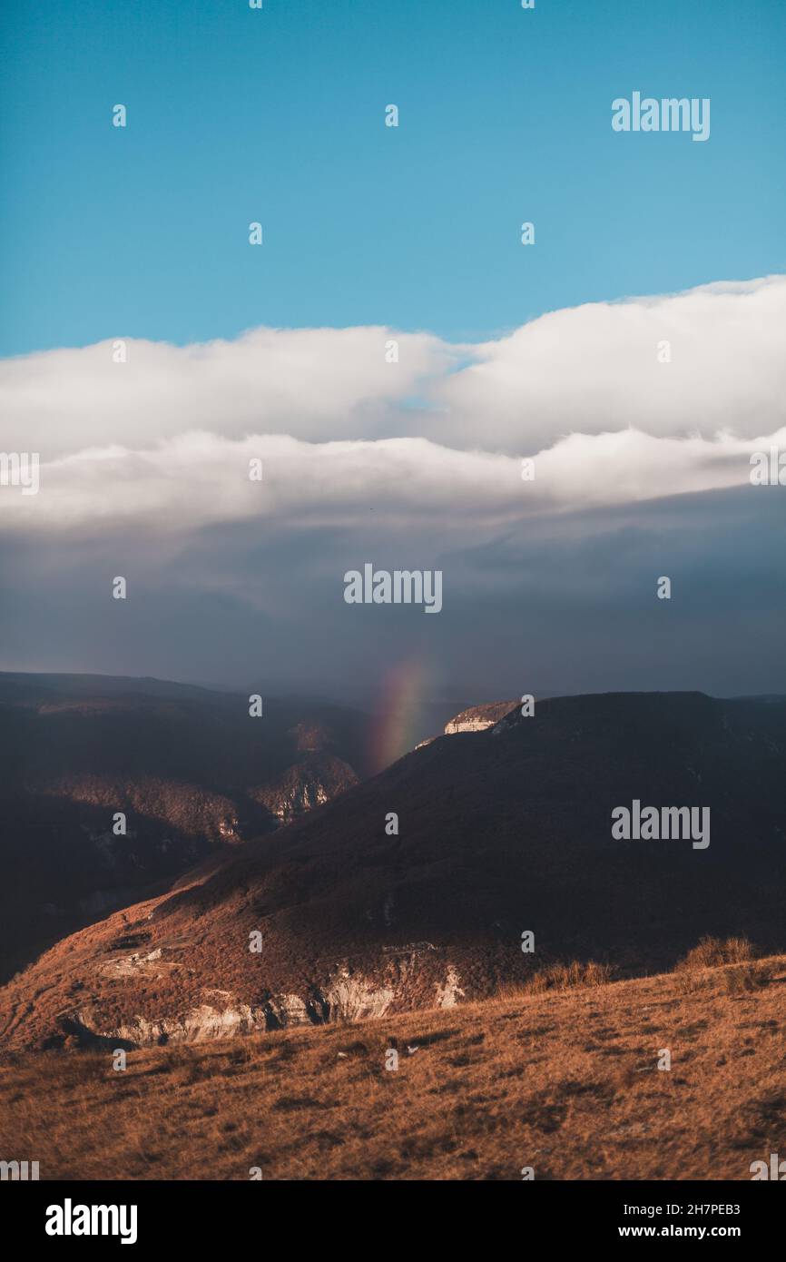 Vue panoramique sur le magnifique arc-en-ciel dans les montagnes.Arc-en-ciel dans le canyon du Dagestan.Vue pittoresque du ciel bleu avec des nuages blancs. Banque D'Images