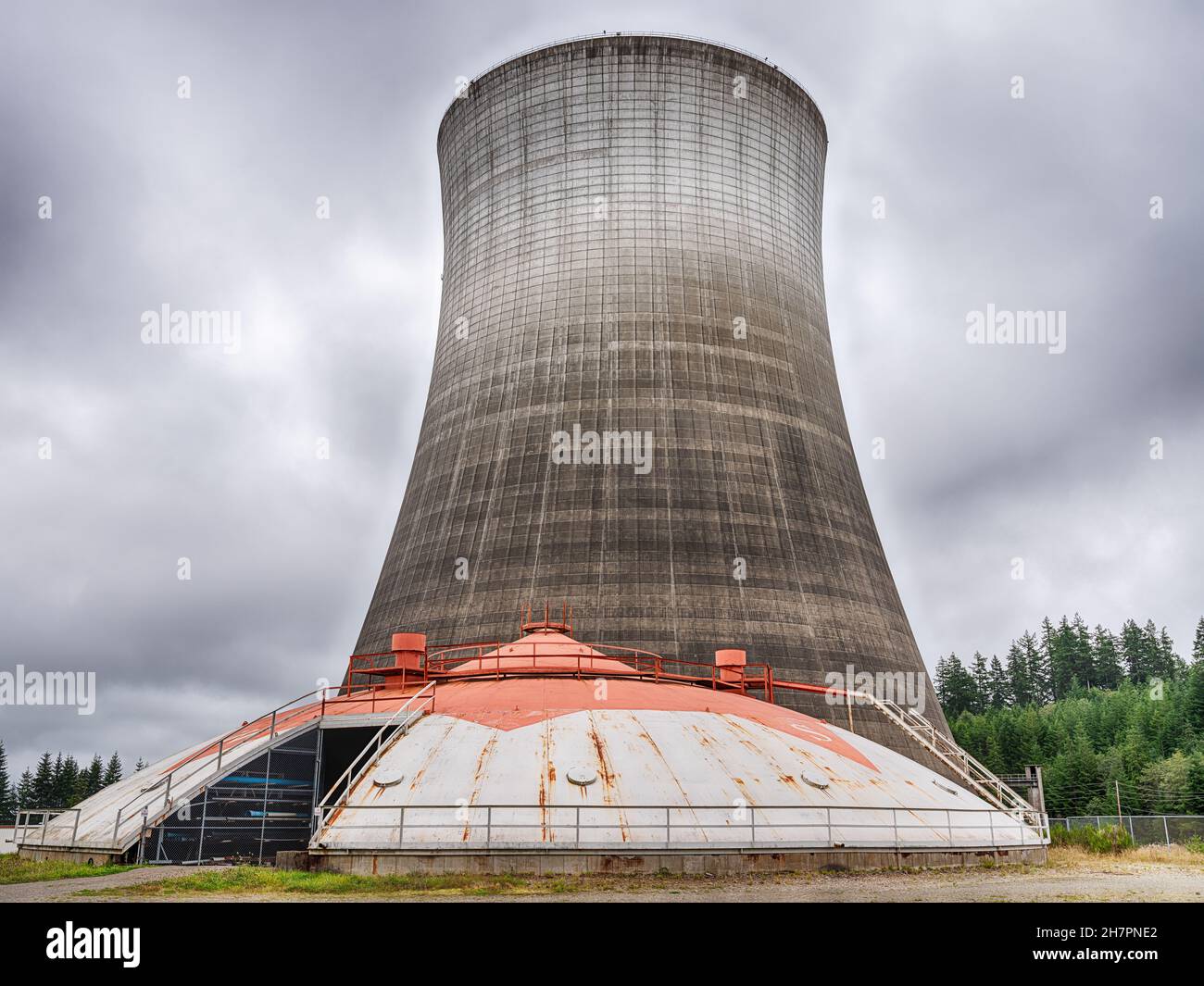 Une tour de refroidissement avec un ancien hangar d'équipement vu d'une route publique à la centrale électrique d'Elma, Washington. Banque D'Images