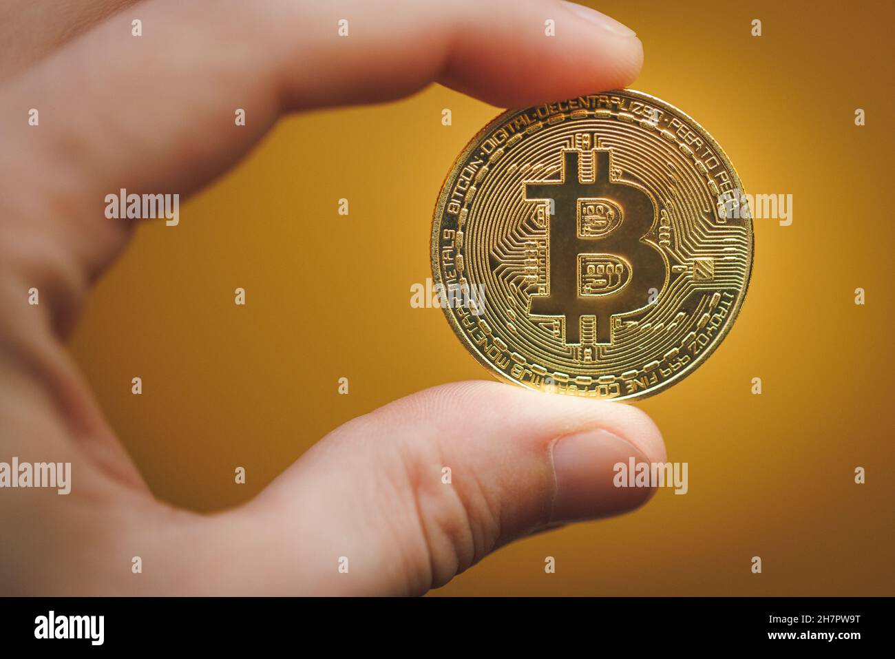 Galice, Espagne - 20 novembre 2021 : main tenant une pièce de monnaie en  bitcoin sur fond jaune Photo Stock - Alamy