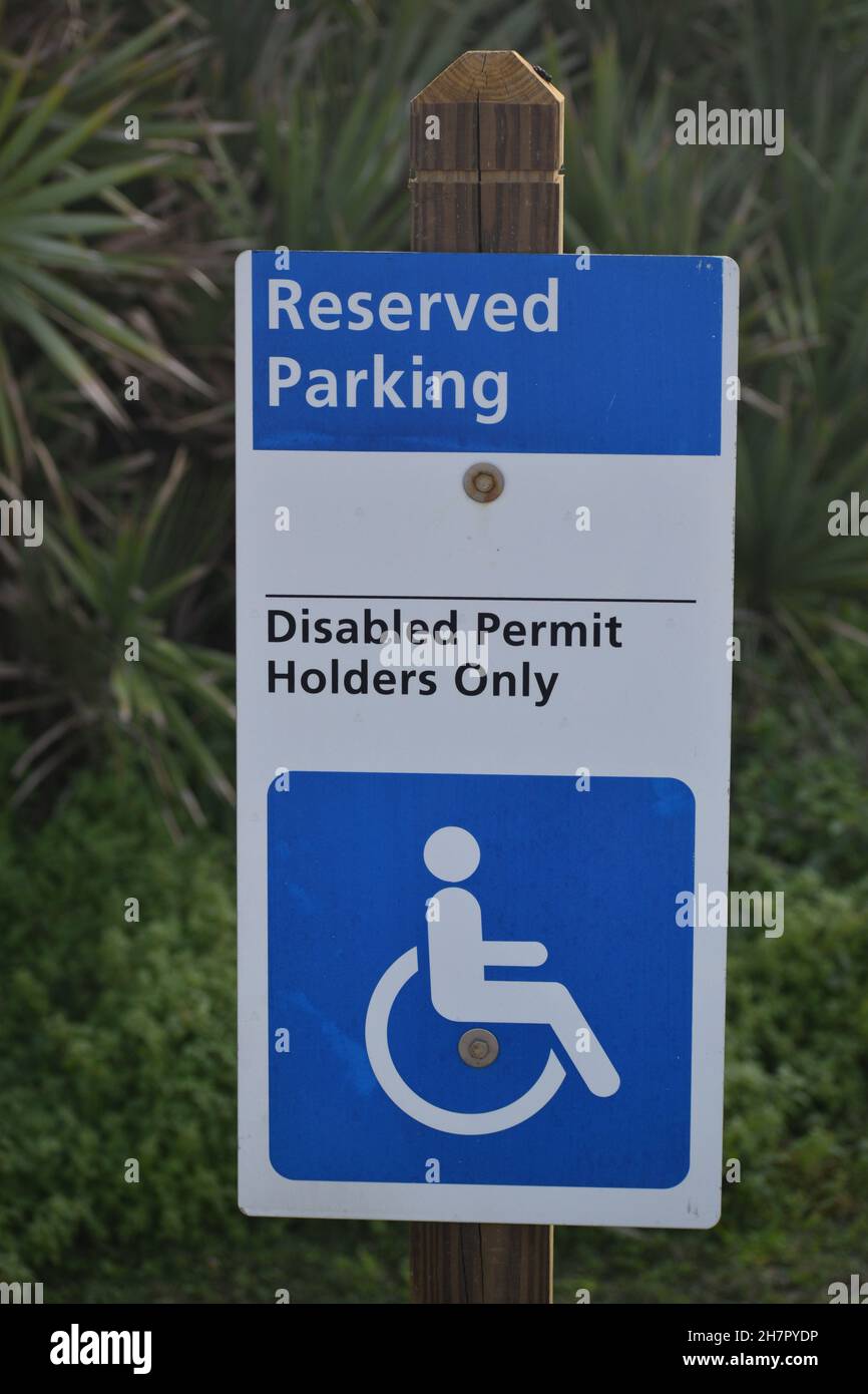 Un panneau bleu et blanc désigne le stationnement pour les personnes handicapées. Banque D'Images