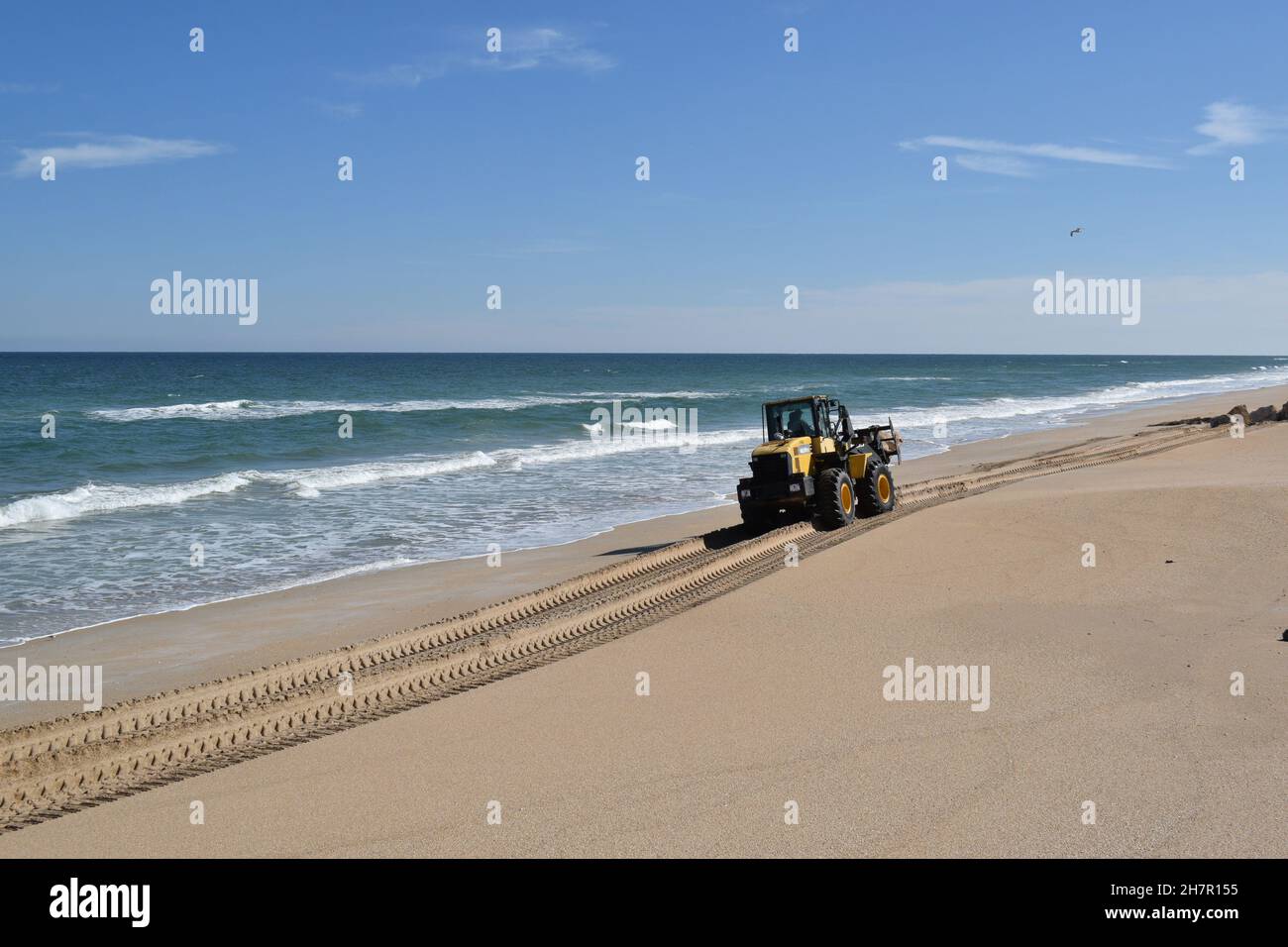 Un équipement lourd déplace un rocher sur la plage. Banque D'Images