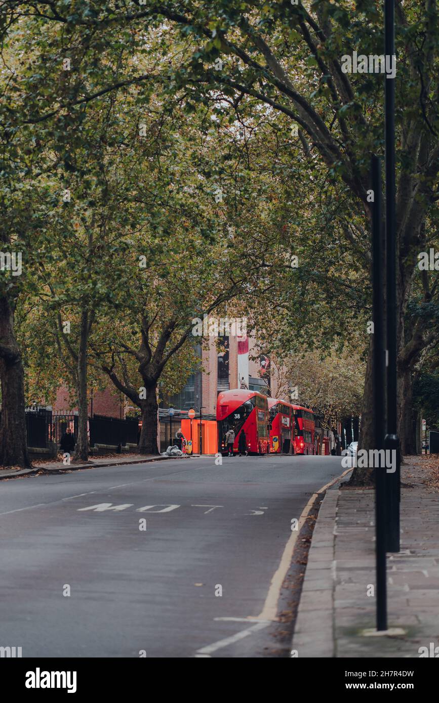 Londres, Royaume-Uni - 23 octobre 2021 : bus à impériale rouge moderne au loin sur une route à Islington, Londres.Les bus rouges emblématiques font partie intégrante de Banque D'Images