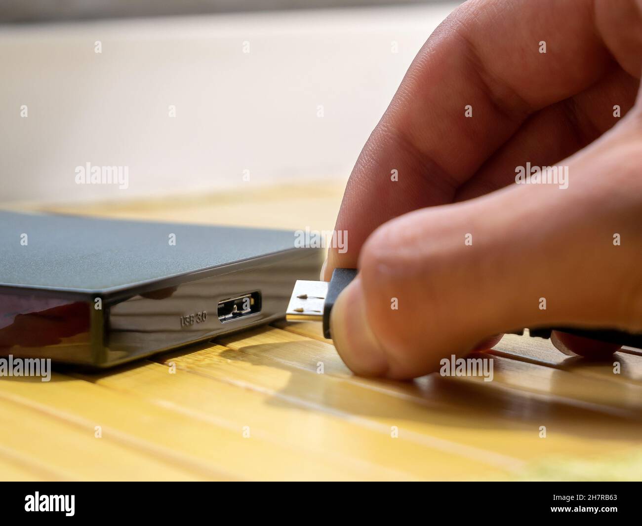 Disque dur USB de type 3.0, homme insérant un câble dans un disque dur  externe portable, détail de l'objet, main très gros plan.Données  numériques, stockage multimédia personnel Photo Stock - Alamy