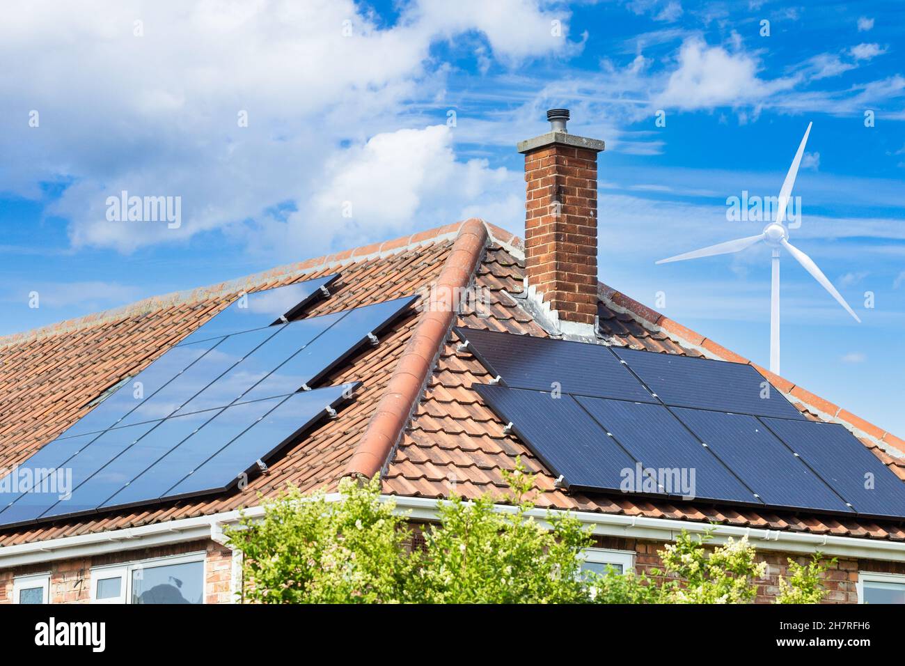 Panneaux solaires sur le toit de la maison au Royaume-Uni avec éolienne.Énergie solaire, renouvelable, verte, propre, alternative.Maison, facture d'énergie domestique... concept Banque D'Images