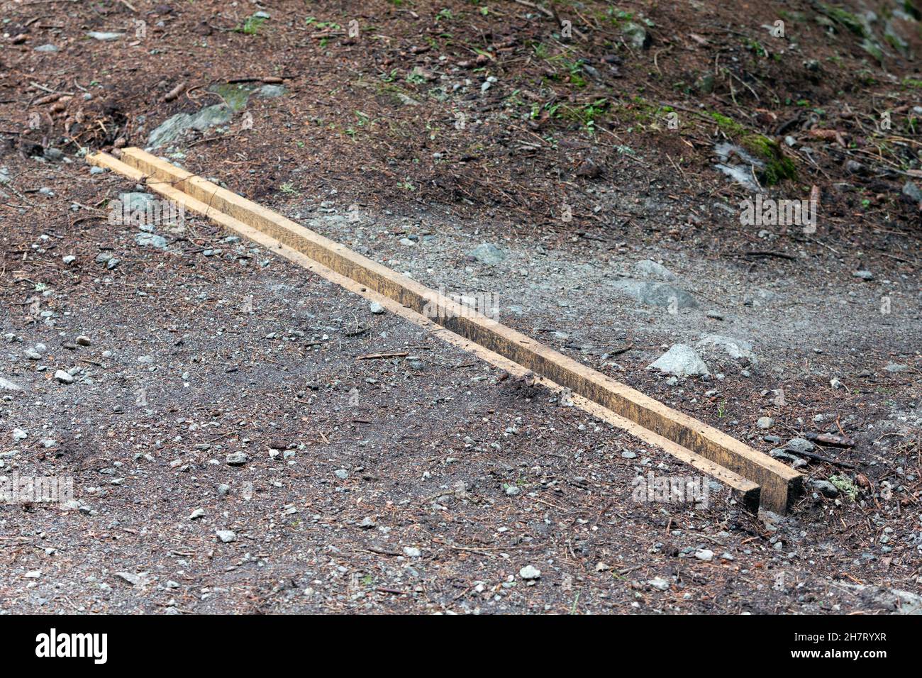 Un nouveau système de dérivation d'eau de pluie en bois, une barre d'eau ou un trempette de drainage sur une route rurale non pavée, de sorte que l'eau de pluie soit déviée et qu'il y ait moins d'érosion o Banque D'Images